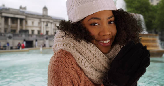 在伦敦度假时, 穿着冬衣保暖的黑人妇女亲密起来