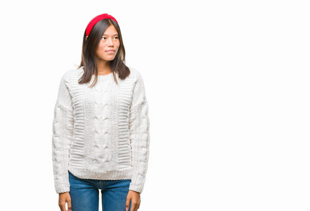年轻的亚洲妇女穿着冬季毛衣在与世隔绝的背景下, 脸上带着微笑, 自然的表情。笑的自信