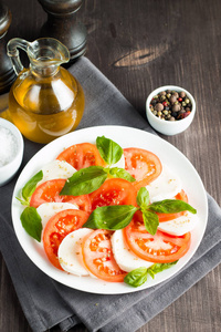 特写照片的 caprese 沙拉与成熟的西红柿, 罗勒, 水牛芝士干酪。意大利和地中海的食物概念。新鲜健康的有机膳食。起动机和开