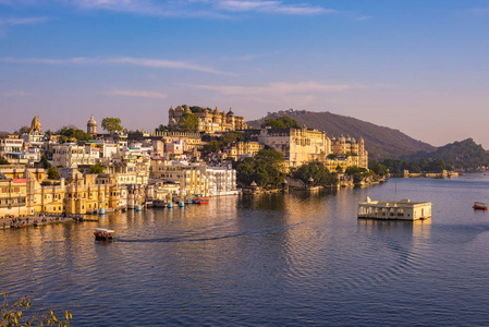 著名的城市宫殿在 Lake Pichola 夕阳的光反射。乌代浦，旅游目的地和旅游景点在拉贾斯坦邦，印度