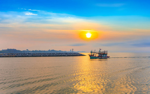 平静海边与美丽的早晨日出海上的渔船