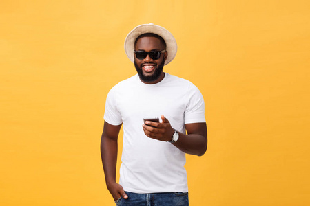 愉快的非洲裔美国人穿着白衬衫使用手机应用程序。快乐的黑皮肤嬉皮士家伙阅读新闻从社交网络在手机
