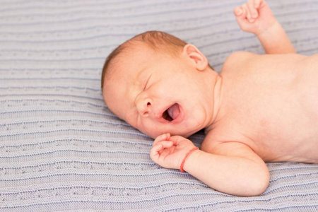 可爱的小宝宝特写。私人照片婴儿针织毯子上。孩子