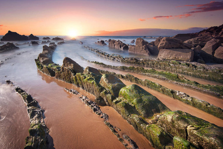 在 barrika 海滩，长满苔藓的岩石的风景日落。毕尔巴鄂，巴斯克人国家