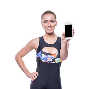 年轻女人穿着运动服运动服显示空白智能手机屏幕孤立在白色背景的快乐健身