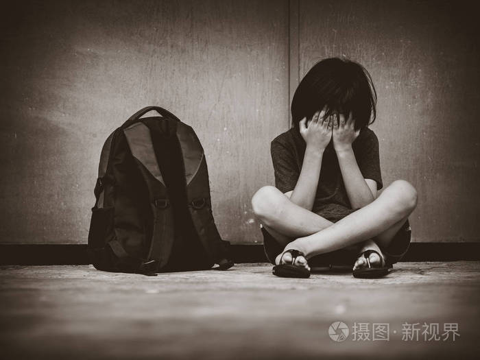 与谷物的复古图片.伤心的孩子坐在地板上等待父的书包
