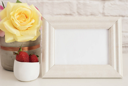架样机。白框架模拟起。奶油相框，花瓶，粉红玫瑰，在金碗草莓。产品架样机。墙上艺术显示模板，墙面砖
