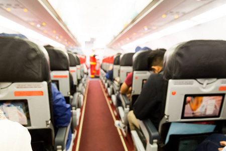 离焦模糊的飞机客舱内部与座椅和乘客