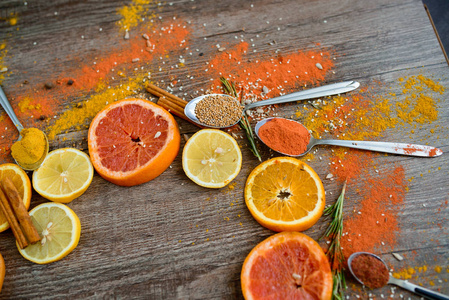 香料 红辣椒 黑胡椒 芥末 葵花籽，橙片上深色木制背景表的柑桔类水果的芳香