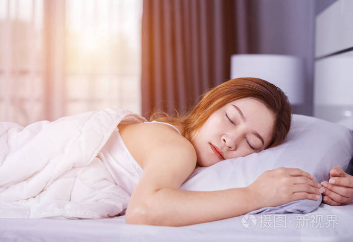 女人睡在床上,用柔和的光线照片-正版商用图片0u5rsx-摄图新视界