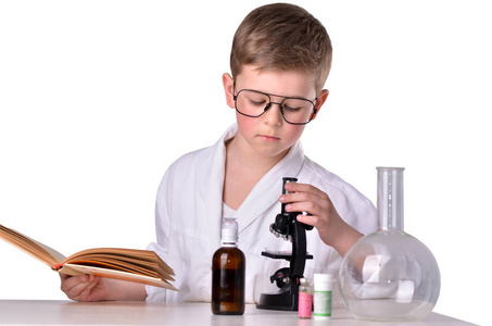 在化学实验室的科学家男孩看起来很 mycroscope