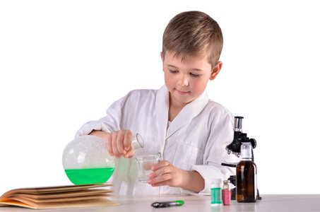 科学男孩注入玻璃烧瓶里出来的绿色液体