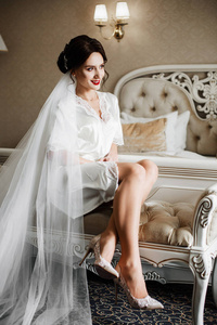 诱人的新娘坐在沙发上的丝袍