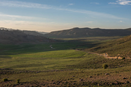 在中间的阿特拉斯山脉在日落，摩洛哥，非洲的高原山谷中长满苔藓