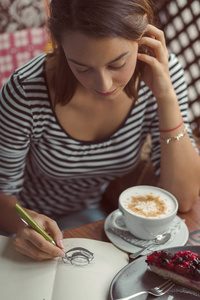 年轻女子坐在室内在城市的咖啡馆
