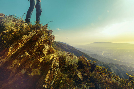 双人类脚座落在山的阳光谷的背景上。旅行 探险和发现的概念
