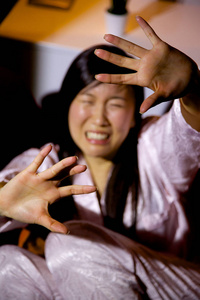 受惊的亚洲女人哭着求助在家里晚上集中在手上