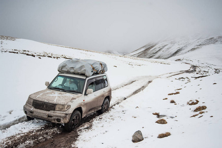 车上山雪道路景观的旅行者。在一座山的 4  4 吉普车车通过，登上峰顶。极端危险的冒险