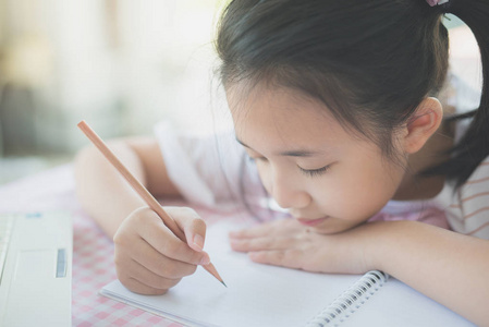 美丽的亚洲女孩写日记在桌子上
