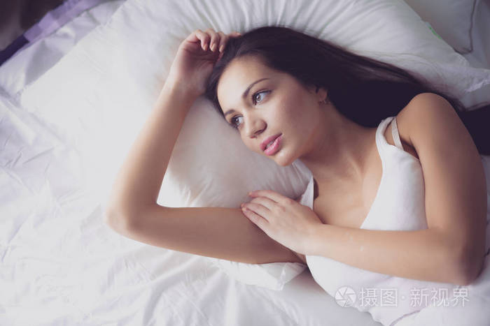 漂亮的女人,躺在家里的床上照片-正版商用图片0u91dl