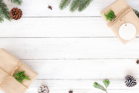 圣诞节杉木针叶，松果和白色仿古木制背景上的礼物