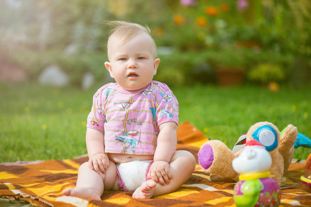 胖胖的可爱的宝宝坐在草地上