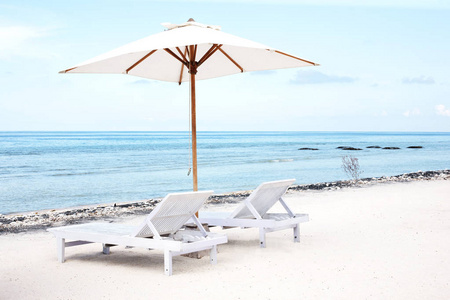 沙滩椅和阳伞在异国热带白色沙图片