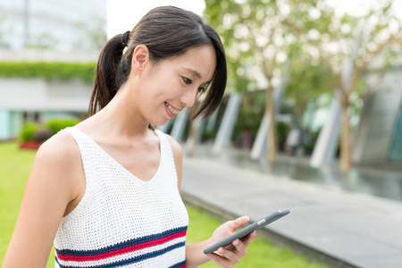 女人在城市公园中使用手机