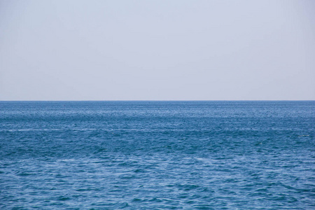 平静的蓝色海面波浪式软表面海洋和蓝色天空背景