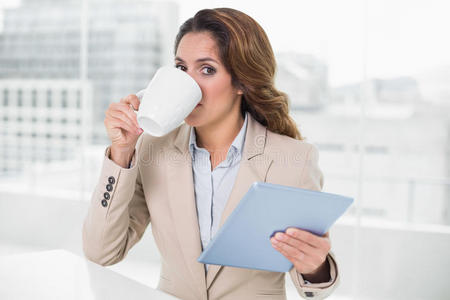 女商人用平板电脑喝咖啡看着镜头