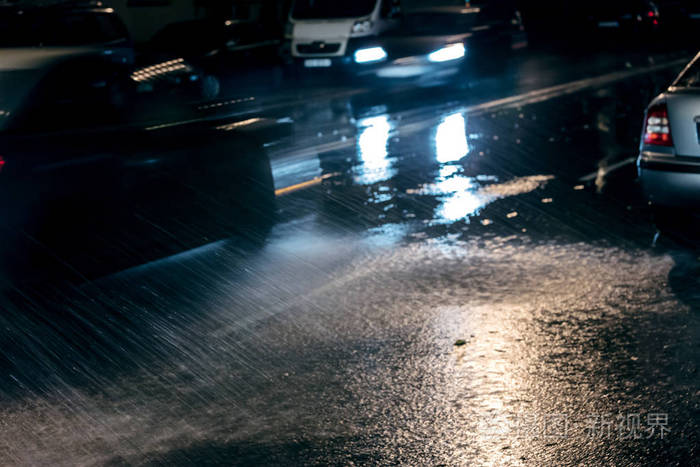 明亮的车灯,在晚上下雨天路上的模糊的汽车