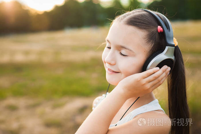 漂亮的孩子,戴着耳机听音乐