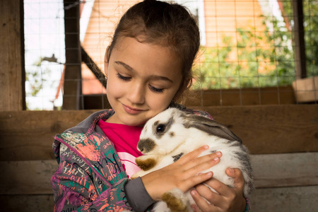 在她的可爱小女孩举行拥抱可爱的兔子