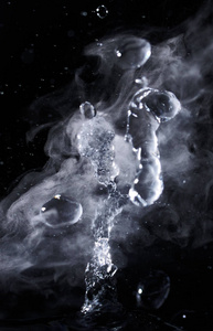 与蒸汽在黑色背景特写的沸腾水飞溅。