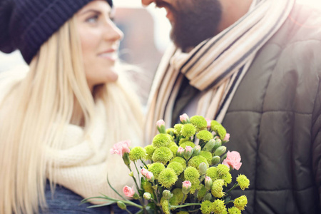 显示对年轻的夫妇与花朵约会在城市的图片