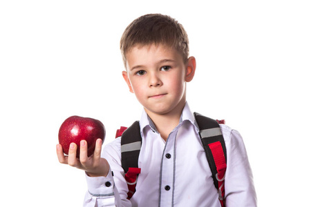 健康的瞳孔与背包抱着一个红苹果, 白色背景, 宏