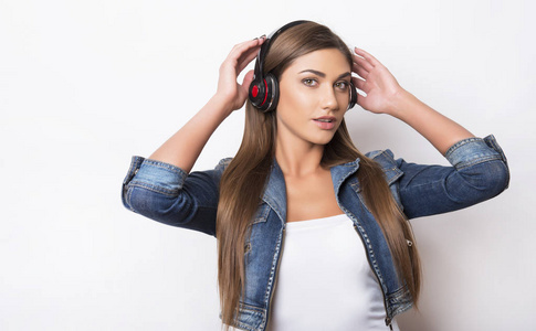 长头发的美丽的少妇用耳机听音乐