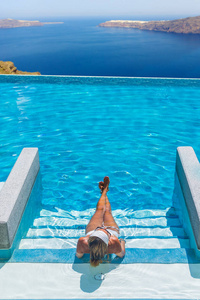 女人在游泳池里享受放松和看风景