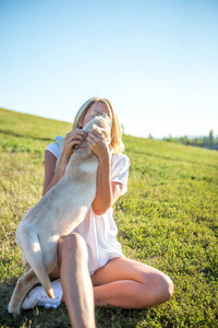 漂亮的女孩和一只小狗拉布拉多犬一起玩