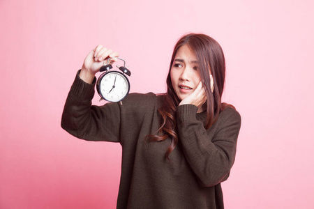 年轻的亚洲女人强调与时钟