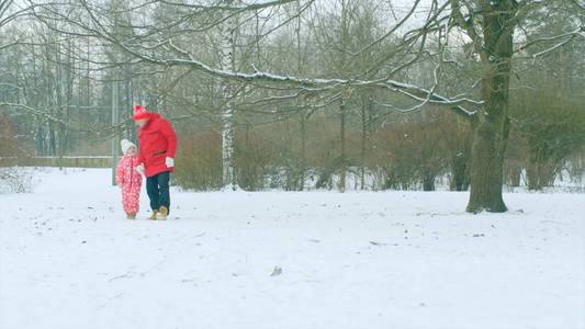 小男孩和他的祖父在冬季公园散步。