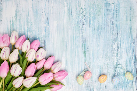 粉红色的郁金香和装饰复活节彩蛋在蓝色的背景。顶部视图, 复制空间。假期背景