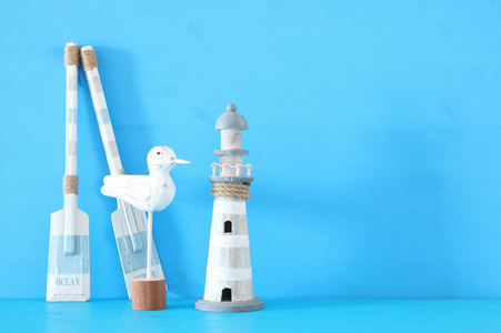航海概念与白色装饰海鸥鸟, 灯塔和木小船桨在蓝色背景下