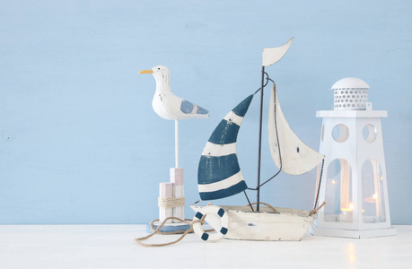 航海概念图像与白色装饰海鸥鸟, 小船和灯塔灯笼在浅蓝色背景下