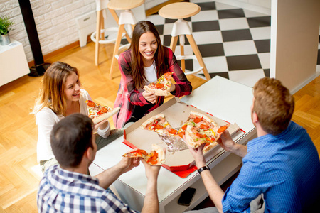 一群年轻的朋友在家里吃披萨, 玩得开心