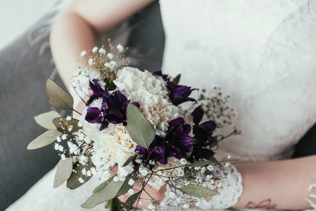 新娘在白色礼服的部分看法与美丽的新娘花束在手