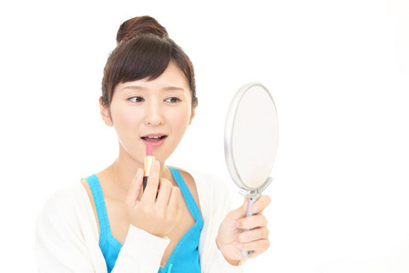 亚洲女人看着她镜子里的脸