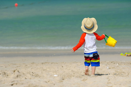 两岁的小孩在沙滩上玩沙滩玩具