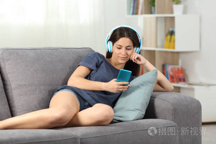 放松的青少年听音乐躺在沙发上