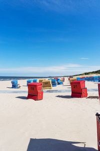 波罗的海阳光明媚的日子里的红沙滩椅